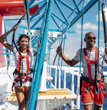 Young couple on Carnival cruise ship hanging out on the SkyCourse activity.