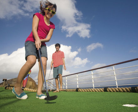 Young couple putting on the mini golf course.