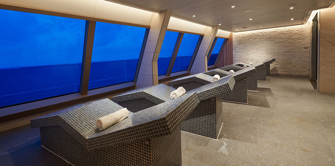 Interior of relaxation beds with ocean view out of window.