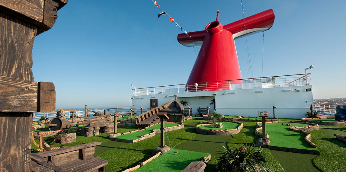 Mini golf course with obstacles and serene ocean view.