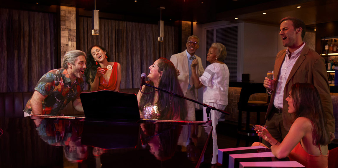 Group of people at Piano bar singing.