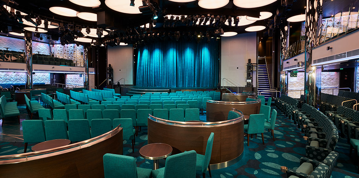 Mid size auditorium that has a large stage with booth style seating.